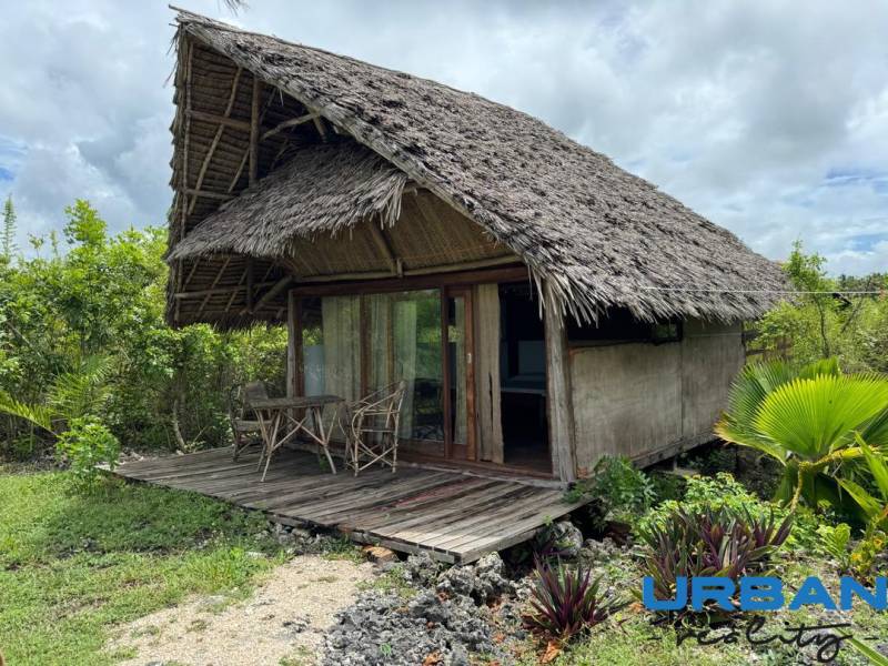 Hagyományos kunyhó fa terasszal a zöldben Kizimkaziban, Kereskedelmi telkek.