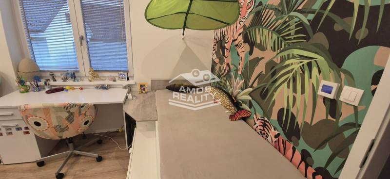 Gyerekszoba íróasztallal és színes tapétával, motívumokkal egy családi házban.