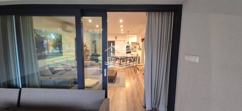 Családi ház belső tere fa dekorációjú padlóval és kényelmes ülőhelyekkel.