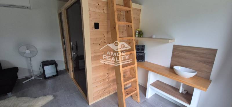 Családi ház belső tere fa szaunával, létrával és sztereó berendezéssel.