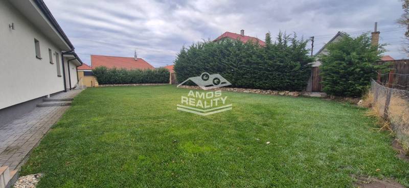 Családi ház Studienkában kerttel, rendezett gyepfelülettel és magas sövénnyel.