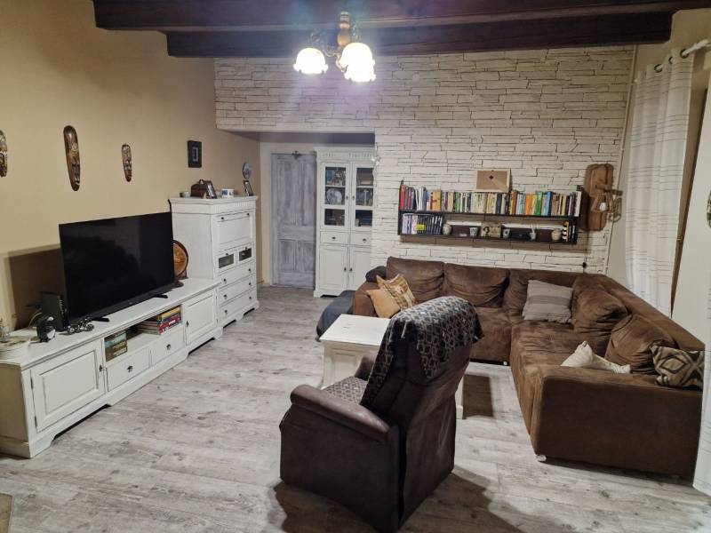 Nappali sarokkanapéval, fehér bútorokkal és fa dekorációjú padlóval egy családi házban.