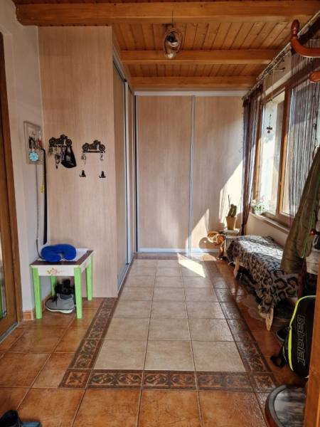 Folyosó csempével, beépített szekrénnyel és paddal a családi házban.