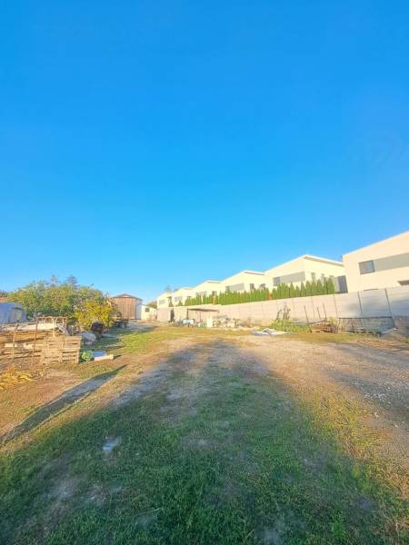 Kilátás a kolárovói családi házakra a hozzájuk tartozó területtel és tiszta kék éggel.