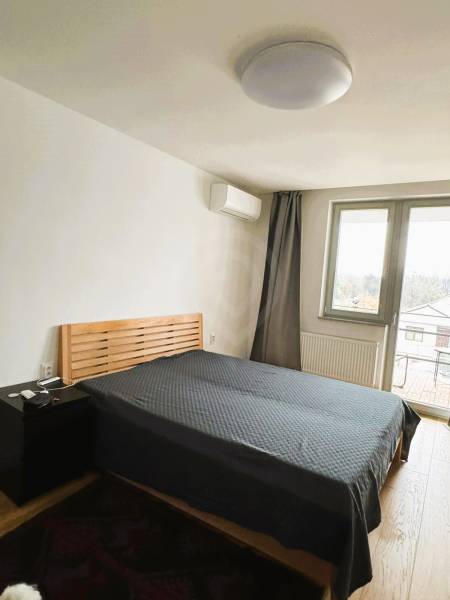 Hálószoba ággyal, éjjeliszekrénnyel és fa dekorációjú padlóval a családi házban.