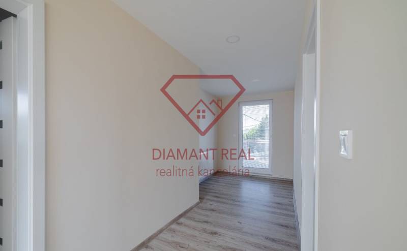 Folyosó egy családi házban fa dekoros padlóval és nagy ablakkal.