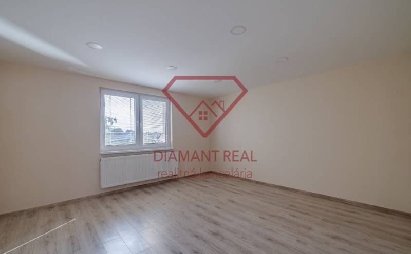 Szoba fa dekor padlóval és nagy ablakkal egy családi házban.