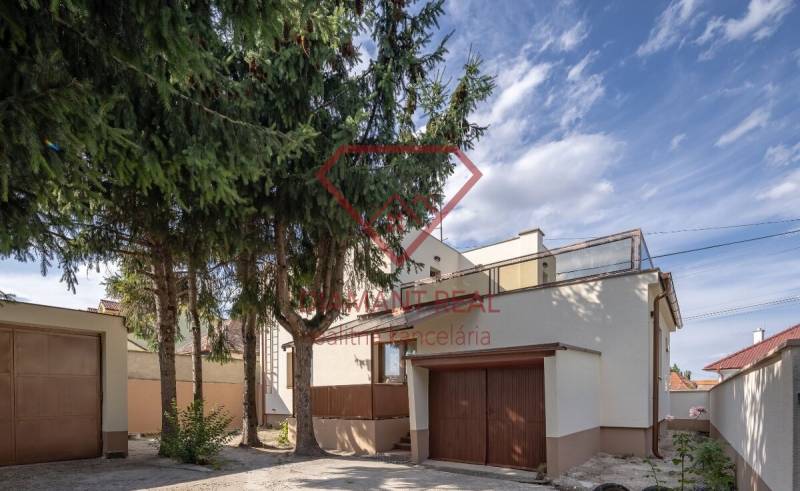 Családi ház a Trnovecká utcában, Trnovec nad Váhom településen, beépített garázzsal és magas fákkal.