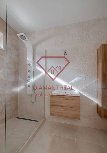 Fürdőszoba zuhanyzóval és fa dekorációjú bútorokkal családi házban.