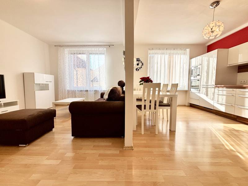 Nappali konyhával egy kétszobás lakásban, fa dekor padlóval.