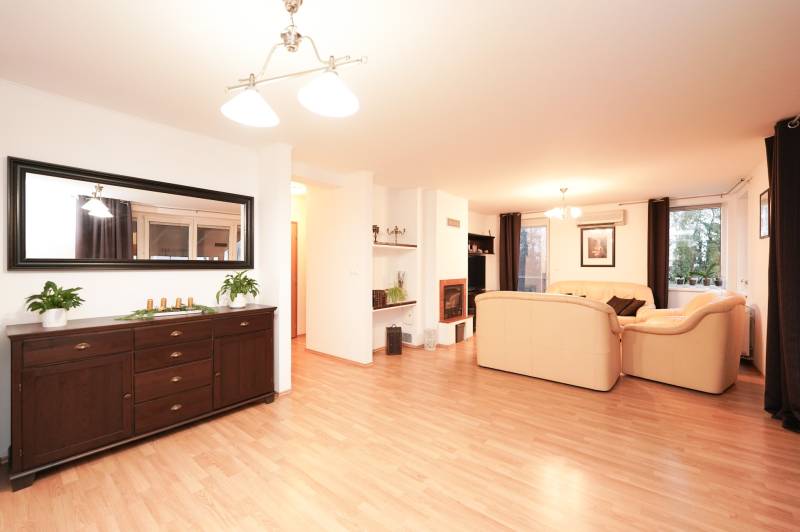 Nappali kandallóval és világos bútorokkal, fa mintázatú padló, családi ház.