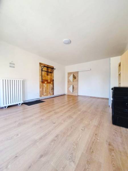 Családi ház belső tere fa dekoros padlóval és fehér falakkal.