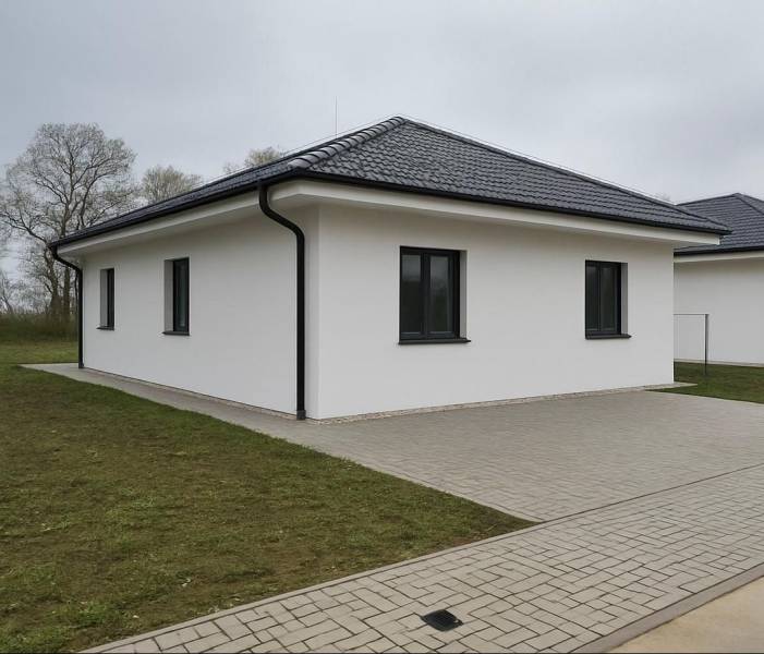 Családi ház Cíferen ferde tetővel és kövezett járdával.