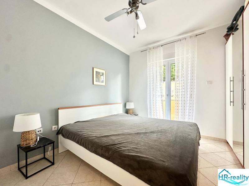 Hálószoba üdülő apartmanban franciaággyal és éjjeliszekrényekkel.