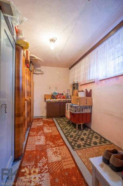 Tárolóhelyiség családi házban szőnyegekkel, polcokkal és dobozokkal.