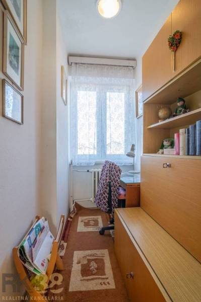 Egy otthonos sarok a családi házban íróasztallal és könyvespolccal.