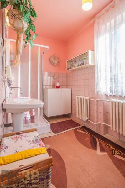 Fürdőszoba családi házban csempékkel és zuhanyzóval, világos rózsaszín falakkal.