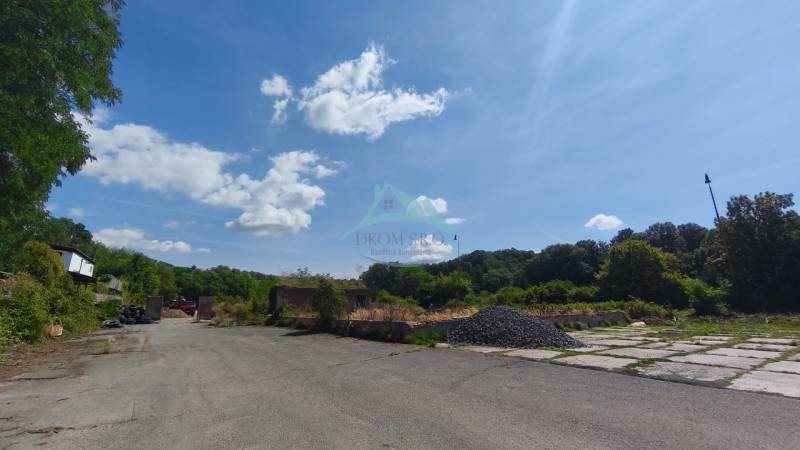 Kereskedelmi telkek a Nagykürtösi Losonci úton, természeti háttérrel és aszfaltozott felülettel.