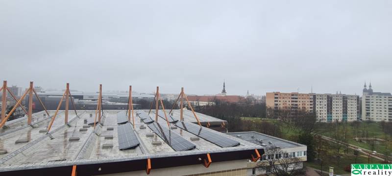 Kilátás a Spartakovská utcára Nagyszombatban, épületekkel és napelemekkel a tetőn.