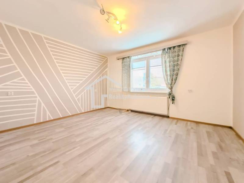 Szoba egy családi házban geometrikus festéssel és fa dekorációjú padlóval.