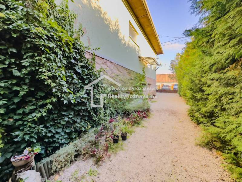 Családi ház kertje Betlérben gazdag növényzettel és virágdíszekkel.