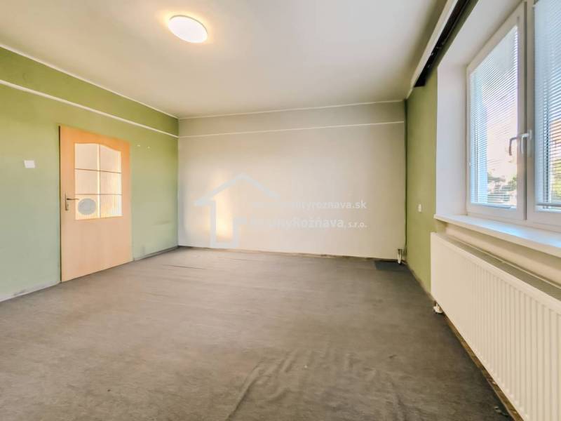 Családi ház belső tere színes falakkal, szőnyeggel és redőnyös ablakkal.