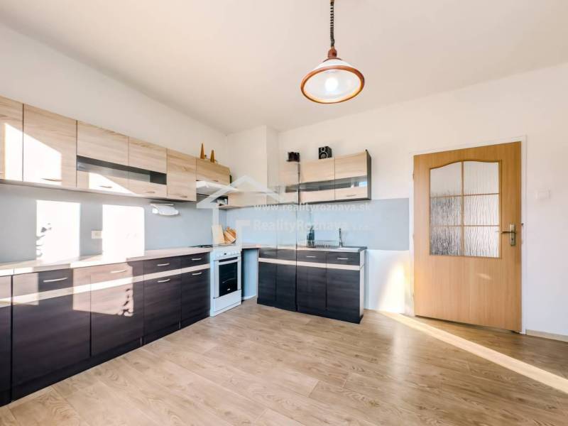 Konyha családi házban fa dekor padlóval és modern konyhabútorokkal.