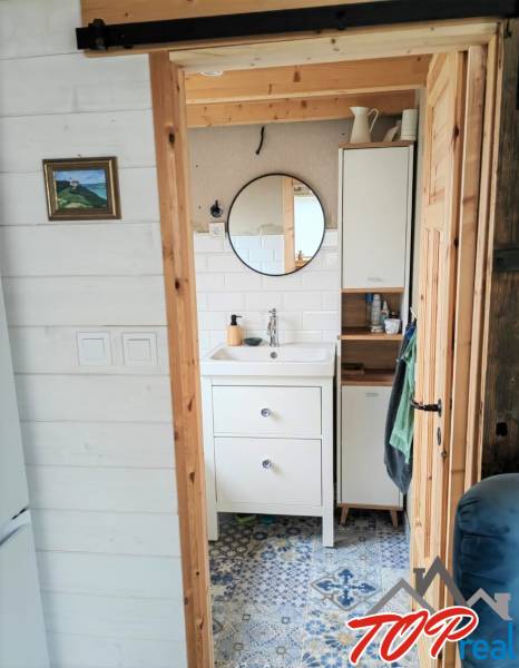 Fürdőszoba családi házban kerek tükörrel és mintás csempével.