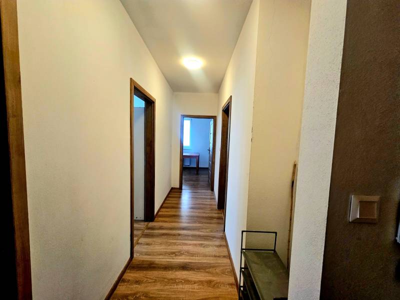 Folyosó fa dekorációs padlóval egy kétszobás lakásban.