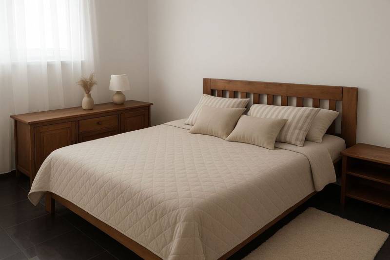 Hálószoba fa bútorokkal, ággyal és díszpárnákkal, tompa színek.