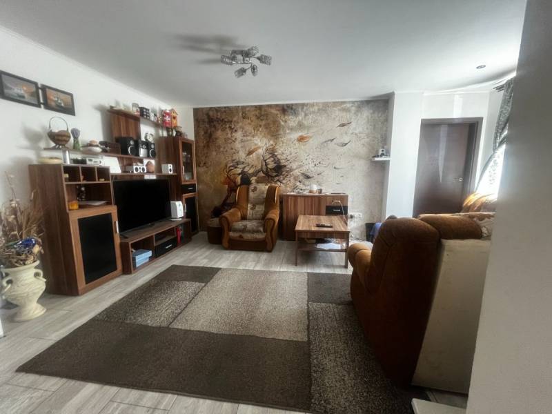 Nappali egy családi házban kényelmes bútorokkal és fa padlódekorációval.