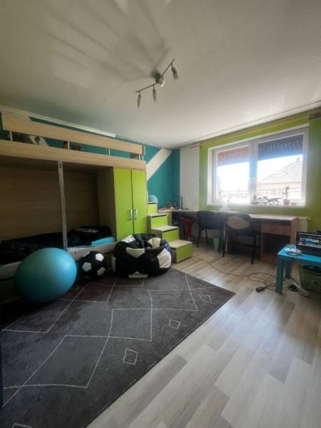 Gyerekszoba családi házban emeletes ággyal, íróasztallal és fa dekorációjú padlóval.