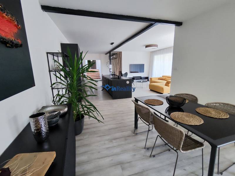 Ebédlő és nappali kanapéval, asztallal és fa dekorációjú padlóval a családi házban.