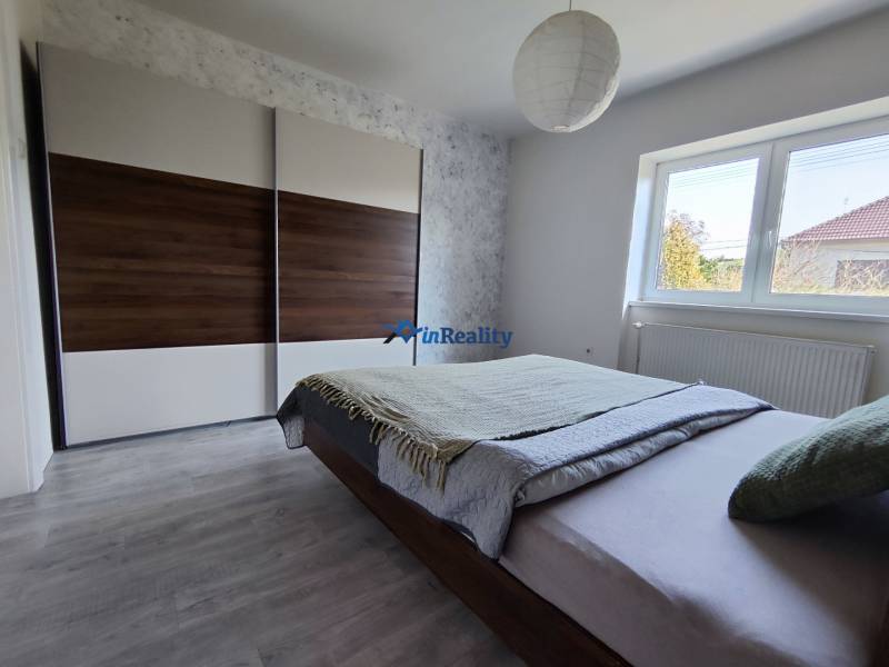 Hálószoba családi házban nagy szekrénnyel, ággyal és fa dekorációjú padlóval.