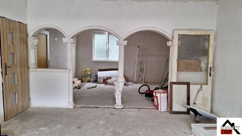 Családi ház belső tér boltívekkel és oszlopokkal, befejezetlen felújítás.