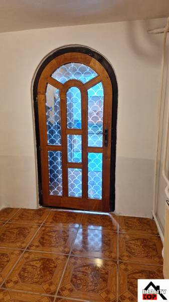 Boltíves faajtó mintás üveggel a családi házban, fa dekoros padló.