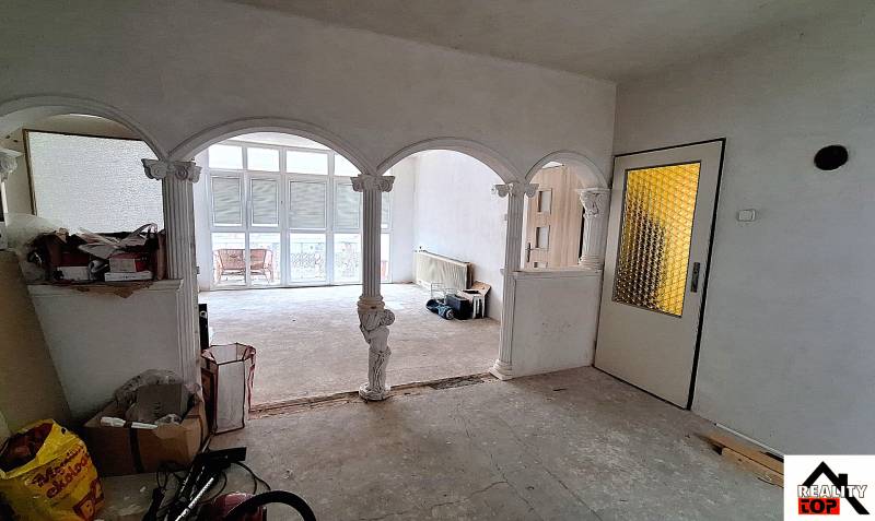 Családi ház belső tere boltívekkel és üvegezett ajtókkal. Javítások folynak.