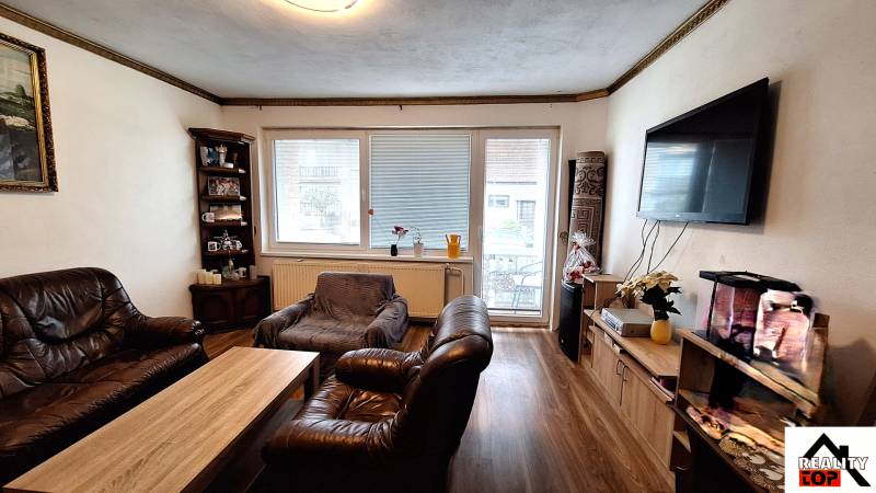 Nappali családi házban bőr bútorokkal és fa dekorációjú padlóval.