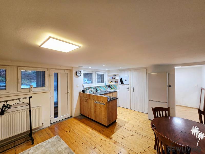 Konyha egy egyszobás lakásban, fa dekoros padlóval és asztallal.