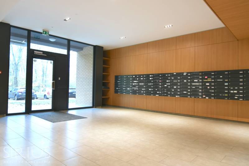 Bejárati előtér postaládákkal és üvegezett ajtókkal egy kétszobás lakás épületében.