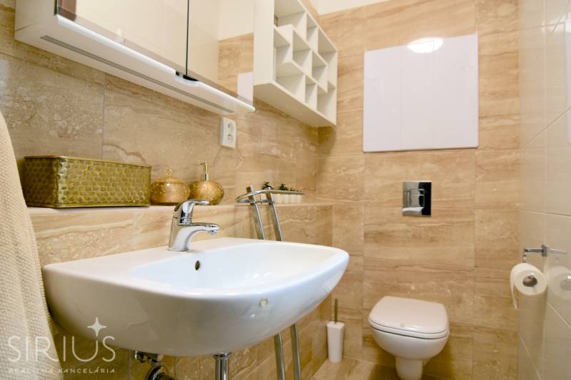 Fürdőszoba egy kétszobás lakásban mosdóval, WC-vel és bézs csempével.