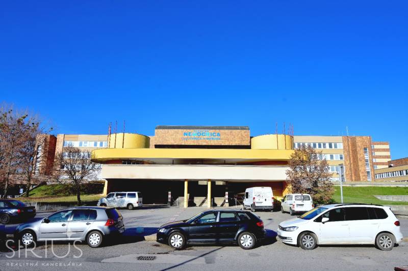 A kórház épülete a pozsonyi Petržalka Antolska utcában, parkolóval és autókkal.