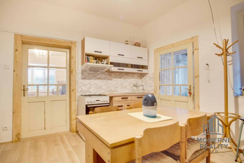 Konyha családi házban, fa bútorokkal és fa dekorációjú padlóval.