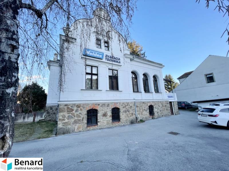 Egy épület a Vajanského utcában Eperjesen, kő földszinttel és fehér homlokzattal.