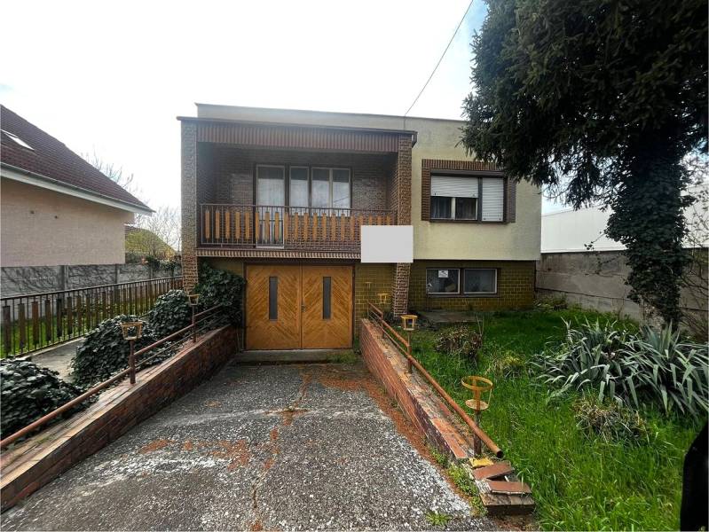 Családi ház Selyén garázzsal, erkéllyel és kerttel, növényzettel és kerítéssel körülvéve.