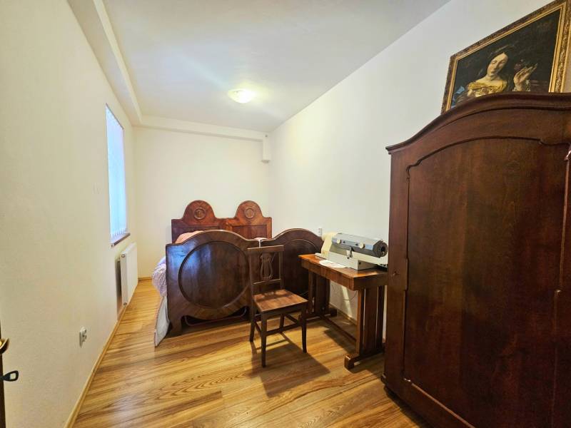 Hálószoba antik bútorokkal, ággyal és szekrénnyel, fa dekorációjú padlóval.