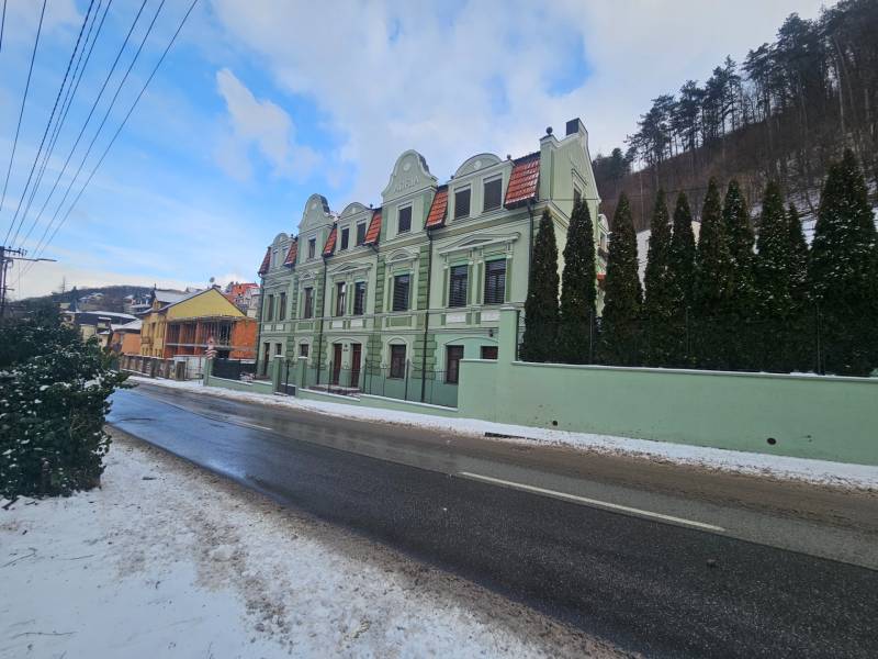 A zöld épület három íves tetővel a Šrobárova utcán, Trencsénteplicen.