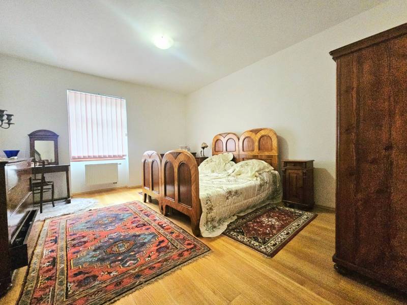 Hálószoba egy 3 szobás lakásban fa dekorációval és vintage bútorokkal.