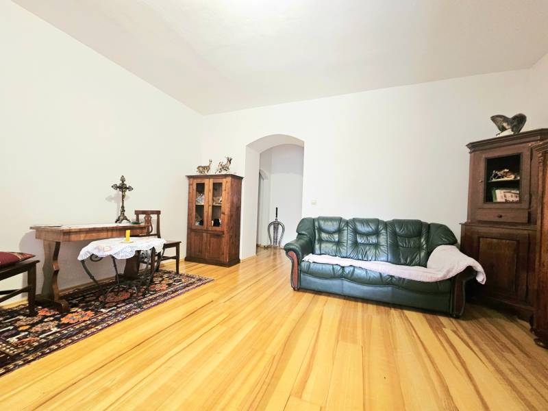 Nappali egy háromszobás lakásban, fa dekorációjú padlóval és fa bútorokkal.