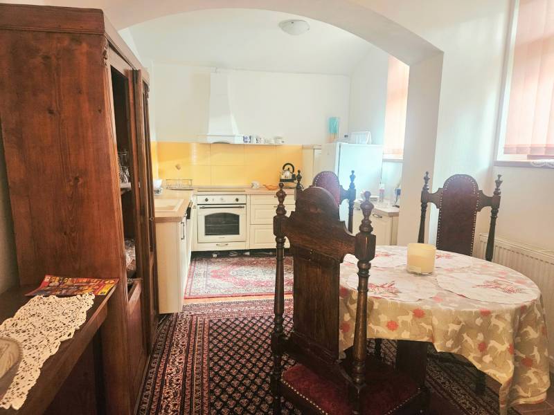 Konyha egy háromszobás lakásban fa bútorokkal és vintage szőnyeggel.